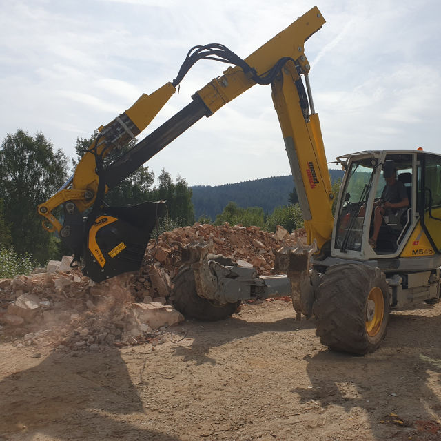 MenziMuck MB-L140 loader on a construction site with trees in the background