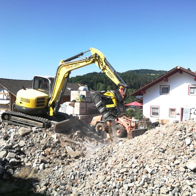 Wacker-Neuson-75Z3 excavator working on a construction site with houses in the background