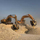 Two excavators working on a construction site with a clear sky.