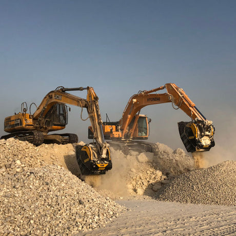 Two excavators working on a construction site with a clear sky.