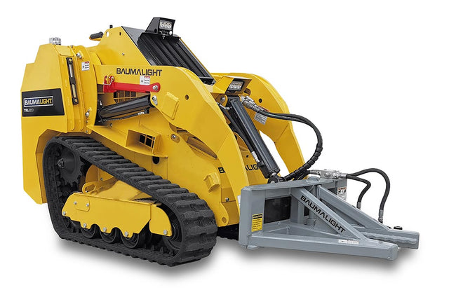 A yellow Baumalight tree puller attachment for mini skid steers, featuring a hydraulic jaw and a cylindrical pulling mechanism.