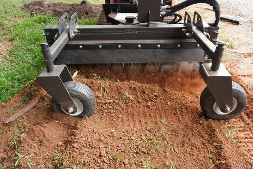 CID Multi-Purpose Power Rake for Mini Skid Steers | Garden tiller on a patch of soil with grass in the background