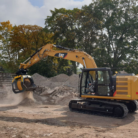 Caterpillar 316 excavator working on a construction site with trees in the background