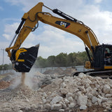Caterpillar 336F excavator breaking up rocks on a construction site.