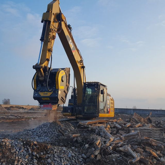 Caterpillar BF90.3 Excavator working on a construction site with a clear sky.