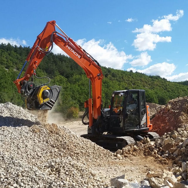 Hitachi MB-C50 excavator working on a construction site with a scenic background