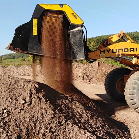 Hyundai-HL757-7 excavator digging into a pile of dirt with a clear sky in the background