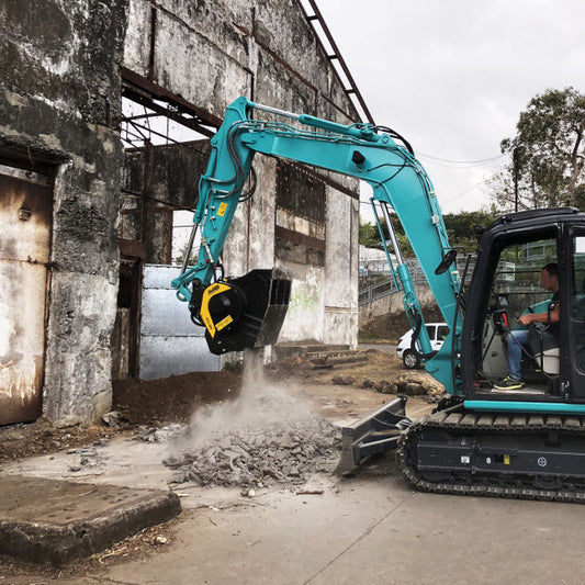 Kobelco Reunion MB-C50 Excavator demolishing a concrete structure with a person operating it.