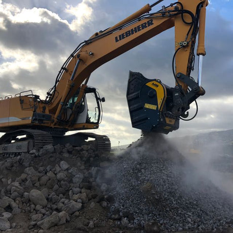 Liebherr-944 excavator operating on a construction site with a cloudy sky.