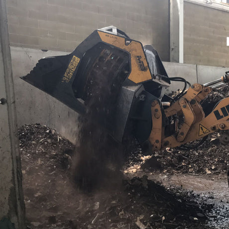 Liebherr MB-LS170 digging into a pile of material with a concrete wall in the background