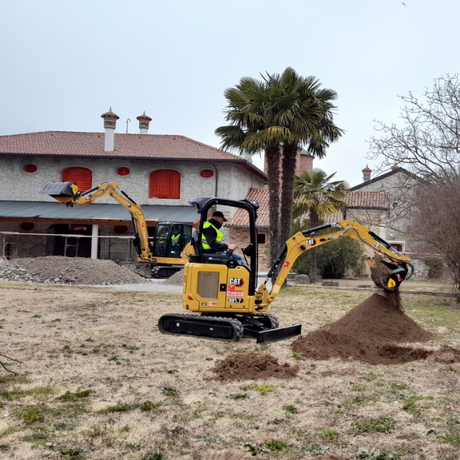 MB - HD206 excavator digging in a construction site with a building and palm tree in the background.