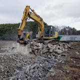 MB Crusher BF80.3 S4 excavator working on a pile of bricks with a cloudy sky in the background