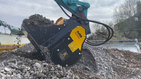 MB HDS307 Screening Bucket on a pile of rocks with a cloudy sky in the background