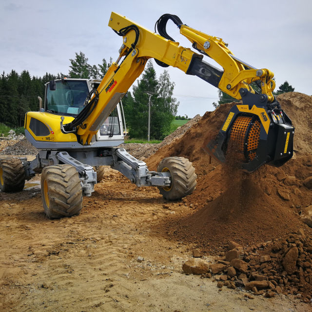 MenziMuck MB-S10 excavator at a construction site with dirt and trees in the background