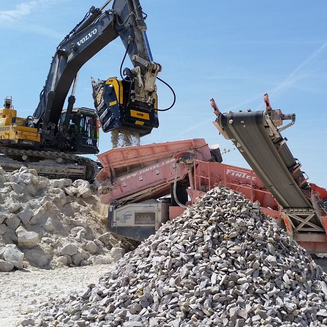 Volvo BF135.8 Excavator loading rocks into a truck on a construction site