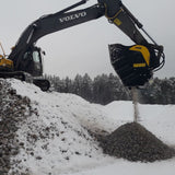 Volvo BF90.3 excavator operating in a snowy landscape with trees in the background