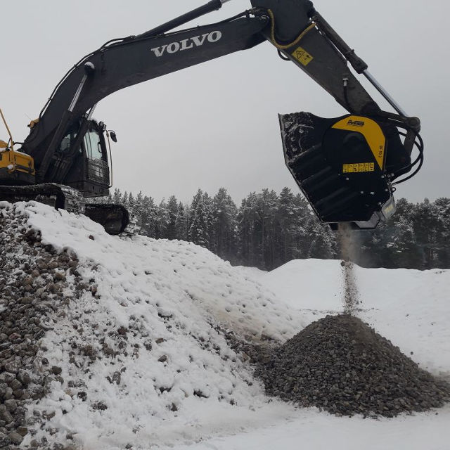 Volvo BF90.3 excavator operating in a snowy landscape with trees in the background