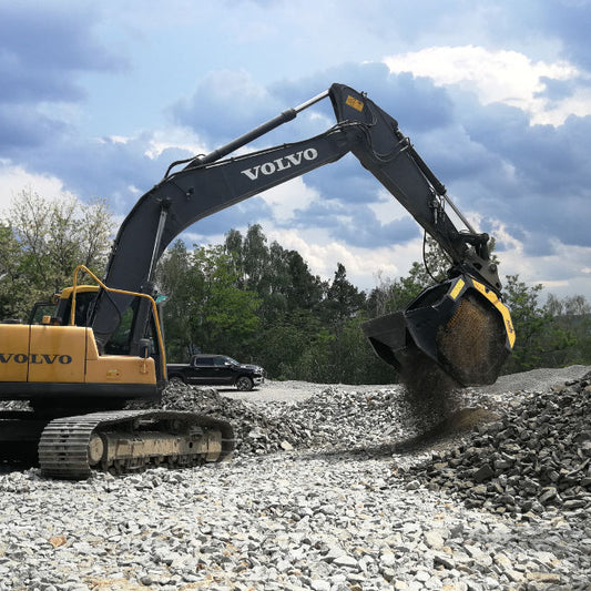 Volvo MB-S18 excavator working on a construction site with trees and sky in the background
