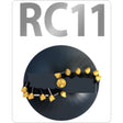 The image shows the Digga RC11 Heavy Duty Rock/Earth Combo Auger Bit, which has a black color with gold-colored tungsten carbide rock pick teeth and a metallic ultra-heavy-duty flighting.