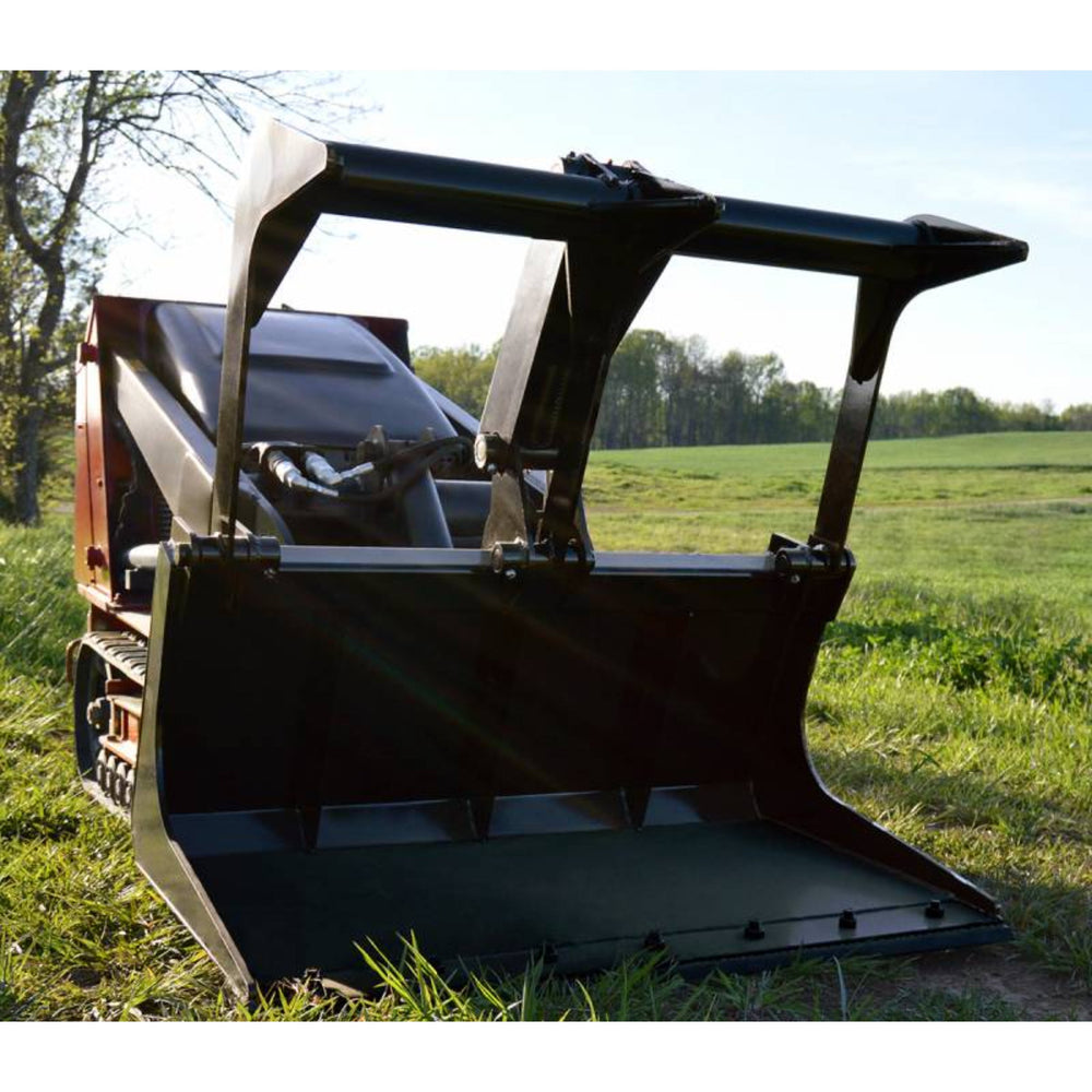 Loflin Fabrication | Mini Skid Steer Grapple Bucket | A black Loflin Fabrication Mini Skid Steer Grapple Bucket placed on grass with a clear sky and trees in the background.